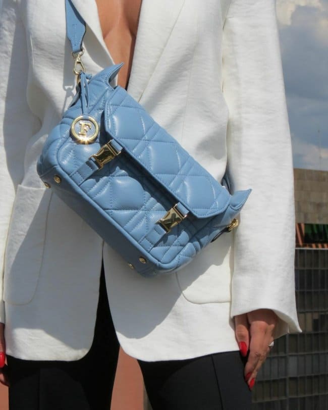 Светло-голубая сумка со стежкой и золотыми элементами.